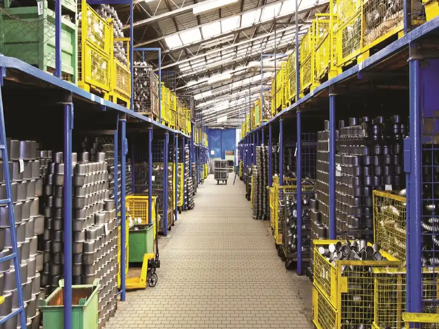 A warehouse aisle of racked components and picking trolleys, laid out for stock counting.
